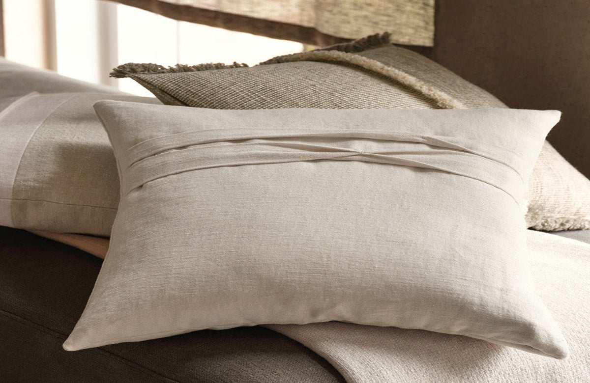 Neatly arranged pillows on a sofa with a neutral color scheme.
