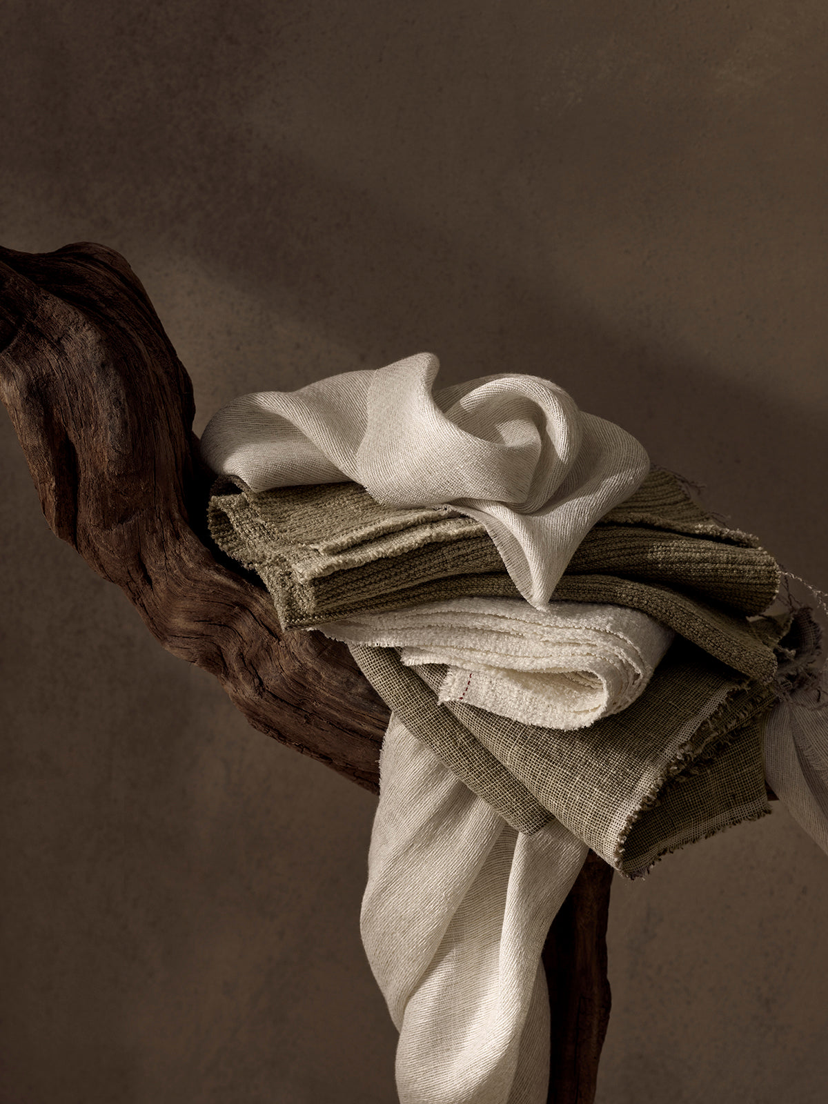 Stack of folded clothes on a wooden surface with a dark background