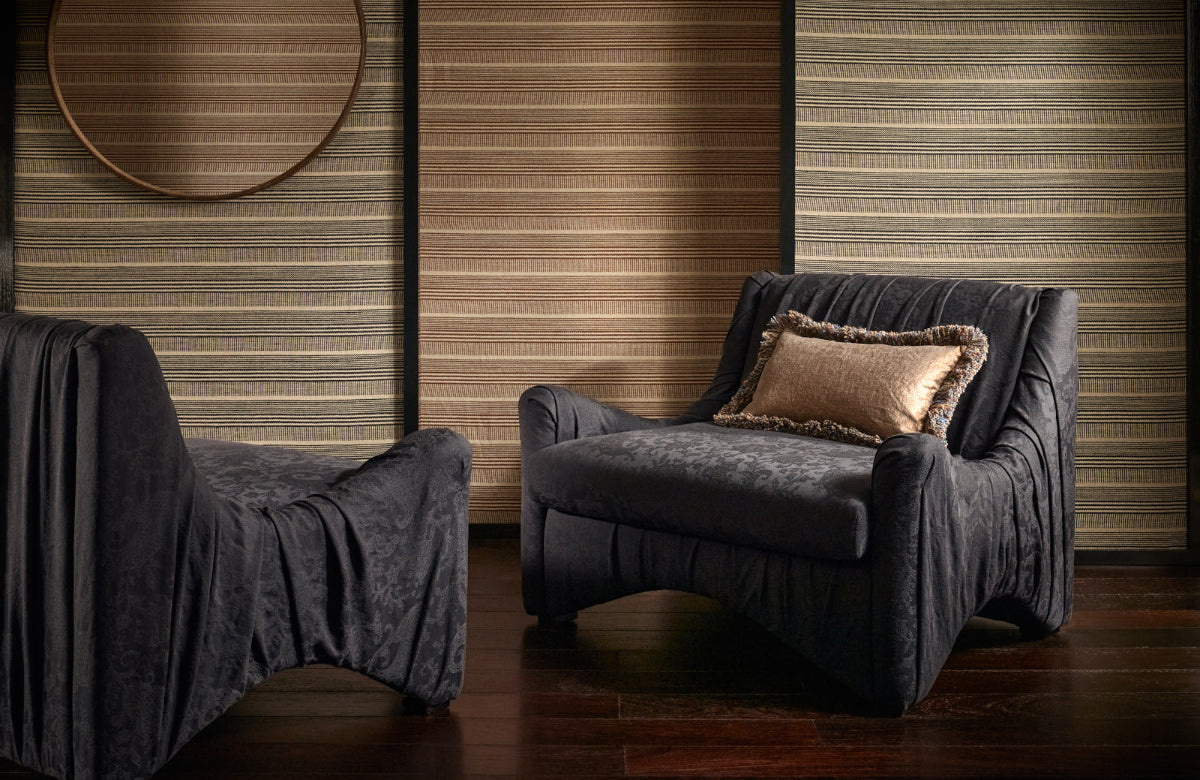 Dark blue armchair with a pillow against a wooden panelled wall.